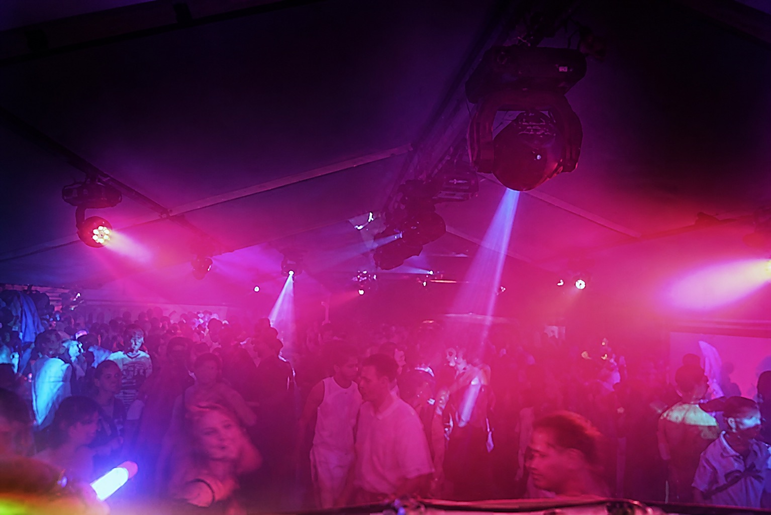 Tanzfläche bei einer Party in pinkem und violettem Licht